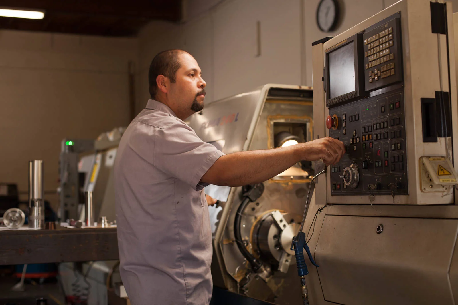 Working at a CNC lathe inside M&M Machining in Ventura